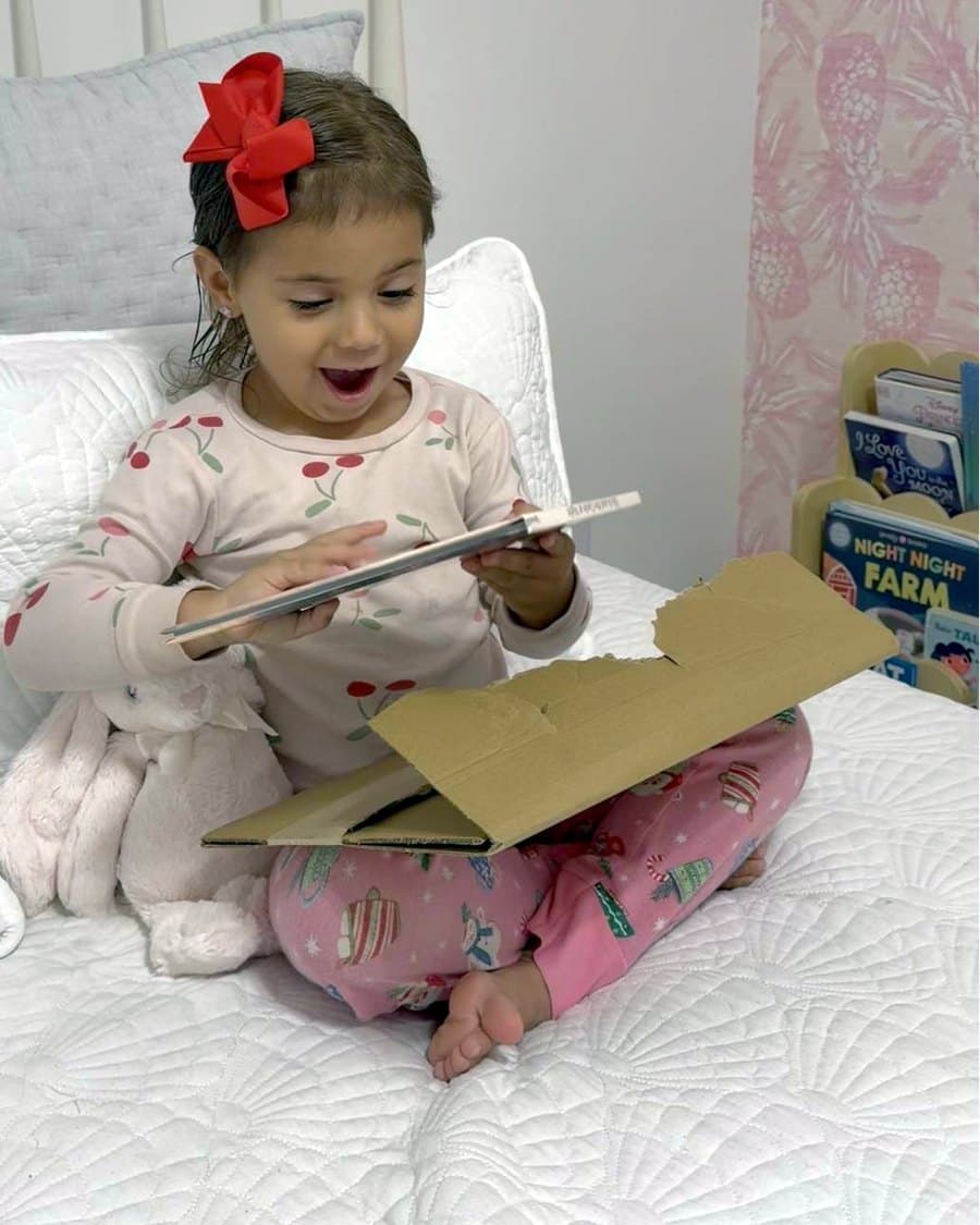 The same child smiling as she opens her personalized book